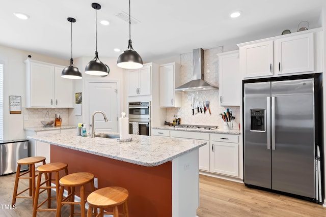 6928 Leesville Rd, Raleigh, NC 27613 - kitchen with appliances with stainless steel finishes, wall chimney exhaust hood, decorative backsplash, white cabinets, and light wood-style floors