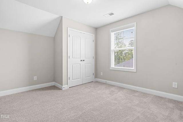 33 E Ravano Dr, Clayton, NC 27527 - unfurnished bedroom featuring light carpet, a closet, lofted ceiling, and baseboards