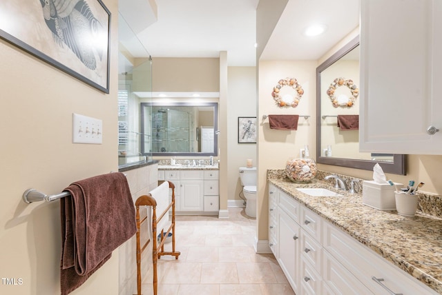 850 N Langdon, Pittsboro, NC 27312 - full bathroom with a shower stall, toilet, two vanities, baseboards, and tile patterned floors
