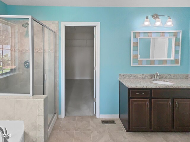 617 Hiddenbrook Dr, Durham, NC 27703 - full bath with a stall shower, a bath, vanity, and baseboards