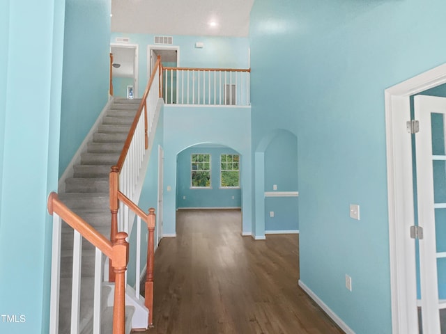 617 Hiddenbrook Dr, Durham, NC 27703 - staircase with wood finished floors, arched walkways, and baseboards
