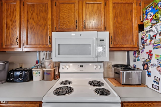 113 W Victoria Ct Unit C, Greenville, NC 27834 - kitchen with white appliances, light countertops, and brown cabinetry