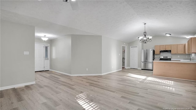 21 Dinghy Dr, Sanford, NC 27332 - unfurnished living room with lofted ceiling, baseboards, a sink, a chandelier, and light wood-style floors