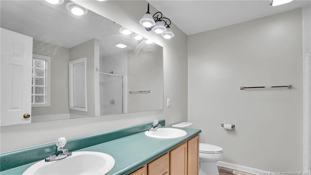 21 Dinghy Dr, Sanford, NC 27332 - bathroom featuring a stall shower, toilet, double vanity, and baseboards