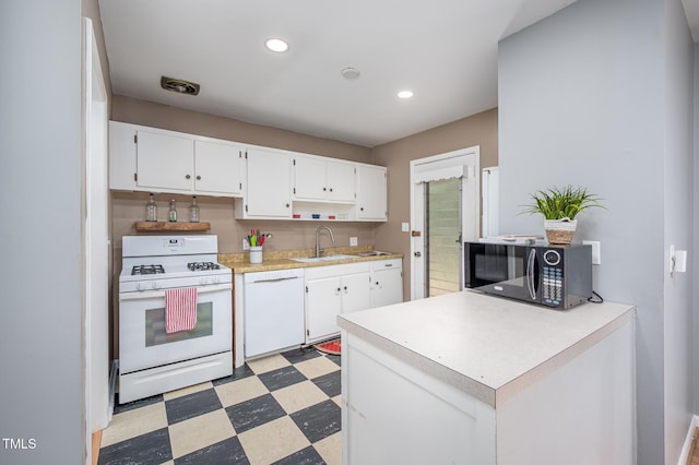 903 W Maynard Ave, Durham, NC 27704 - kitchen featuring white appliances, light floors, white cabinets, light countertops, and a sink