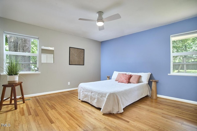 903 W Maynard Ave, Durham, NC 27704 - bedroom with light wood finished floors, multiple windows, and a ceiling fan