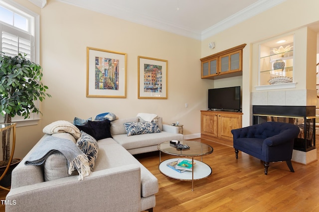 3928 Bentley Bridge Rd, Raleigh, NC 27612 - living room with light wood-style flooring, crown molding, and a tiled fireplace