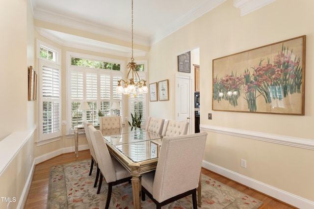 3928 Bentley Bridge Rd, Raleigh, NC 27612 - dining space with wood finished floors, a chandelier, crown molding, and baseboards