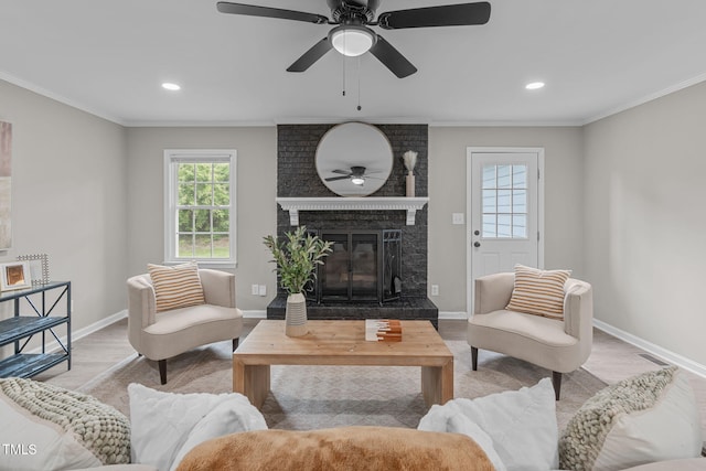 5804 Heathill Ct, Raleigh, NC 27603 - living area featuring a brick fireplace, light wood-type flooring, ceiling fan, baseboards, and ornamental molding