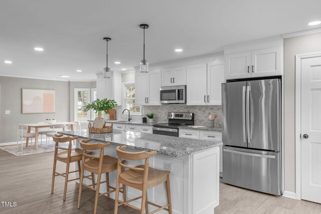 5804 Heathill Ct, Raleigh, NC 27603 - kitchen featuring appliances with stainless steel finishes, a sink, crown molding, white cabinetry, and decorative backsplash