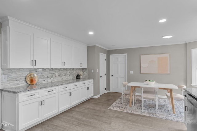 5804 Heathill Ct, Raleigh, NC 27603 - kitchen with stainless steel dishwasher, backsplash, white cabinetry, light stone counters, and crown molding