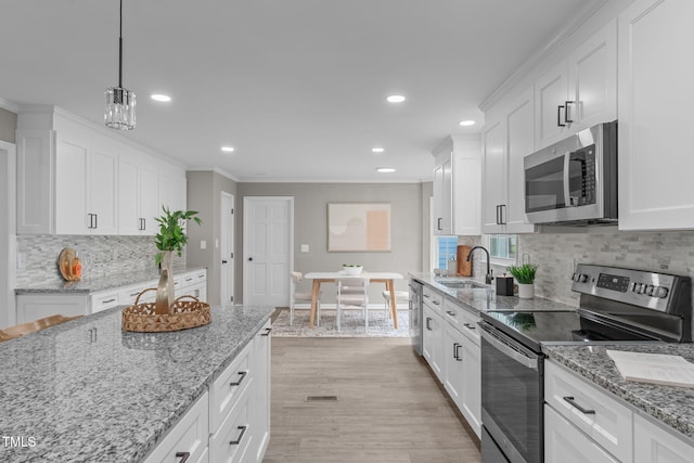5804 Heathill Ct, Raleigh, NC 27603 - kitchen with stainless steel appliances, a sink, ornamental molding, white cabinetry, and tasteful backsplash