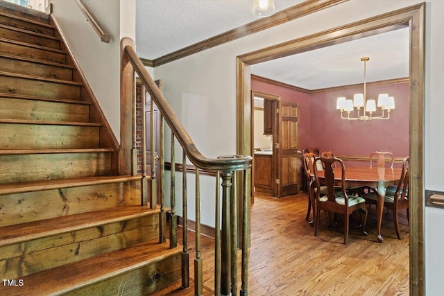 5125 Penny Rd, Raleigh, NC 27606 - stairs with ornamental molding, a chandelier, and wood finished floors