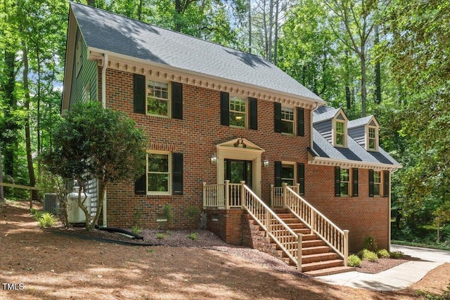 5125 Penny Rd, Raleigh, NC 27606 - colonial home featuring brick siding, a shingled roof, and driveway