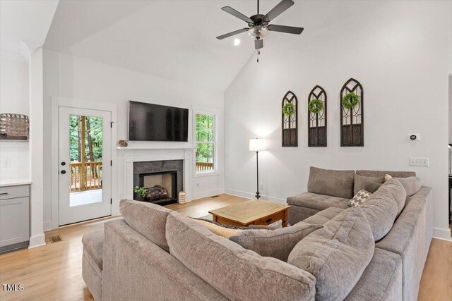 210 Sorrel Dr, Franklinton, NC 27525 - living area with a high end fireplace, ceiling fan, light wood-style floors, high vaulted ceiling, and baseboards