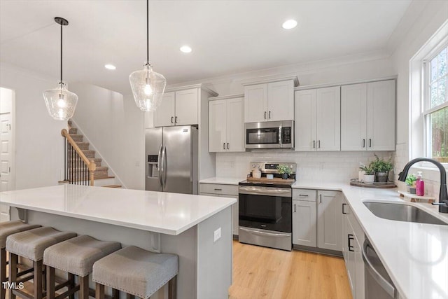 210 Sorrel Dr, Franklinton, NC 27525 - kitchen with appliances with stainless steel finishes, a sink, decorative backsplash, a breakfast bar, and a center island