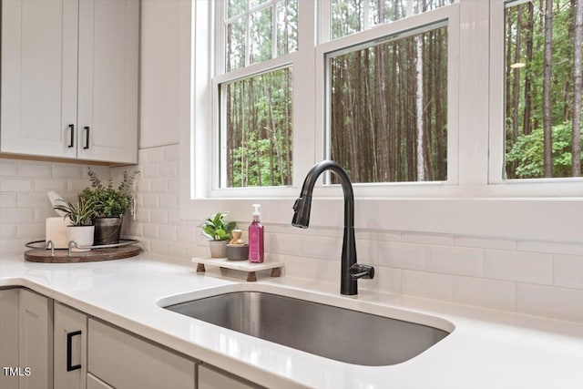 210 Sorrel Dr, Franklinton, NC 27525 - kitchen view of a sink, tasteful backsplash, light countertops, and white cabinetry