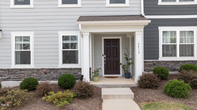 6415 Mentor Pl, Raleigh, NC 27616 - view of exterior entry featuring stone siding and roof with shingles