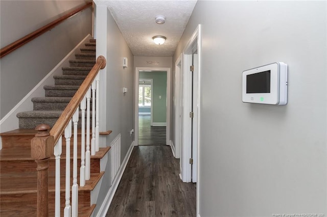 526 E Stack St, Saint Pauls, NC 28384 - hallway featuring dark wood-style floors, a textured ceiling, stairway, and baseboards