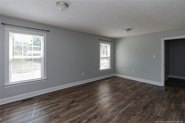 526 E Stack St, Saint Pauls, NC 28384 - unfurnished room featuring a textured ceiling, dark wood finished floors, and baseboards