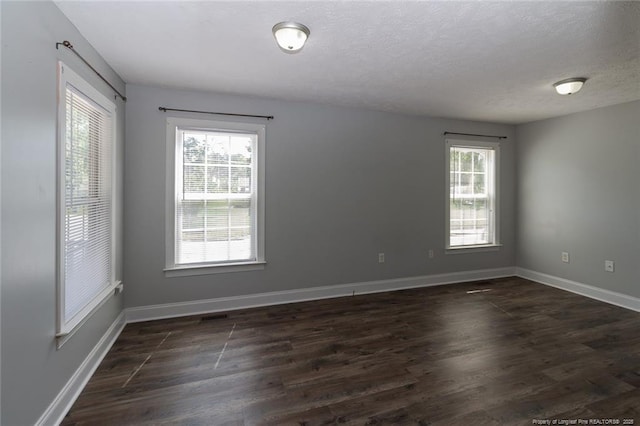 526 E Stack St, Saint Pauls, NC 28384 - unfurnished room with healthy amount of natural light, dark wood-style flooring, baseboards, and a textured ceiling