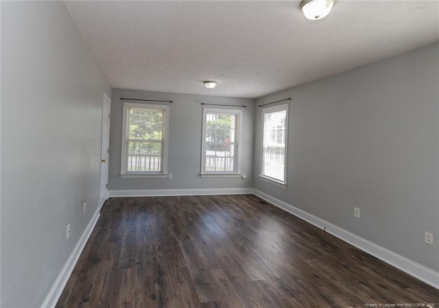526 E Stack St, Saint Pauls, NC 28384 - unfurnished room featuring a textured ceiling, dark wood-style flooring, and baseboards