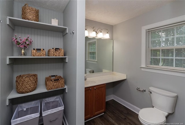 526 E Stack St, Saint Pauls, NC 28384 - half bath with wood finished floors, a textured ceiling, baseboards, vanity, and toilet