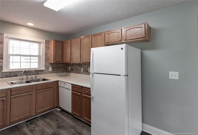 526 E Stack St, Saint Pauls, NC 28384 - kitchen featuring white appliances, a sink, dark wood-style flooring, backsplash, and light countertops