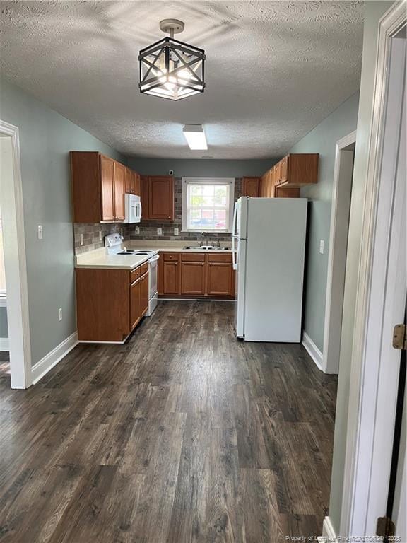 526 E Stack St, Saint Pauls, NC 28384 - kitchen with white appliances, dark wood-type flooring, a textured ceiling, light countertops, and brown cabinetry