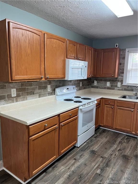 526 E Stack St, Saint Pauls, NC 28384 - kitchen featuring white appliances, dark wood-style flooring, tasteful backsplash, light countertops, and a textured ceiling