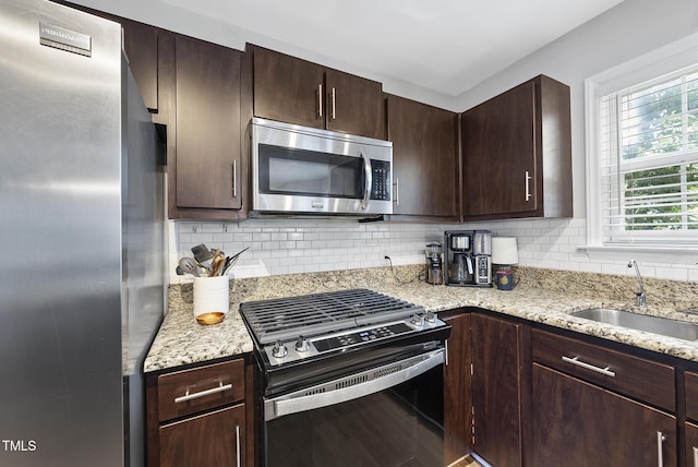 9212 Sayornis Ct, Raleigh, NC 27615 - kitchen with stainless steel appliances, a sink, dark brown cabinets, and decorative backsplash