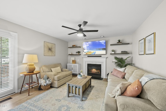 9212 Sayornis Ct, Raleigh, NC 27615 - living area with a fireplace with flush hearth, ceiling fan, wood finished floors, and baseboards