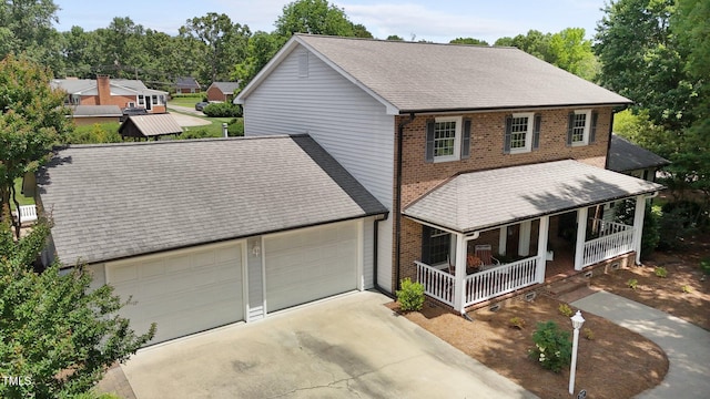 2127 Somers Ave, Burlington, NC 27215 - traditional-style house with a porch, brick siding, concrete driveway, an attached garage, and roof with shingles