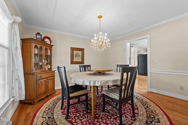 2127 Somers Ave, Burlington, NC 27215 - dining area featuring light wood-type flooring, ornamental molding, a chandelier, and baseboards