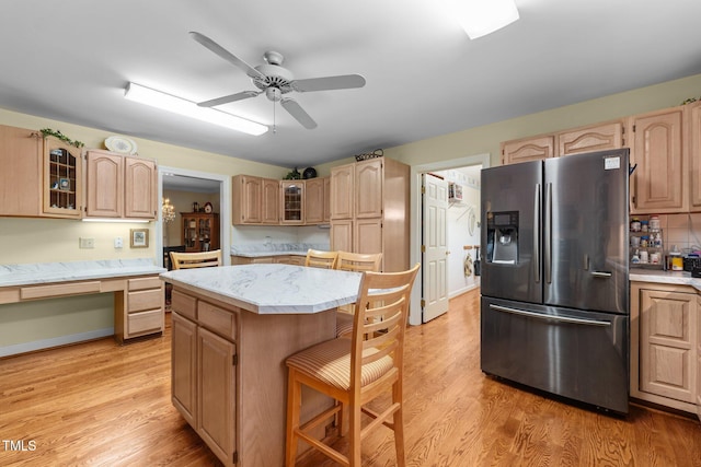 2127 Somers Ave, Burlington, NC 27215 - kitchen with stainless steel fridge with ice dispenser, light countertops, a kitchen island, a kitchen bar, and glass insert cabinets