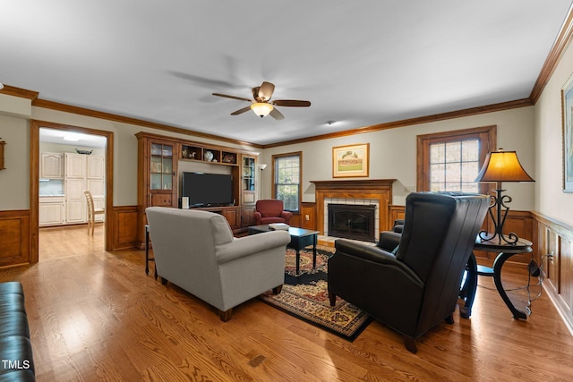 2127 Somers Ave, Burlington, NC 27215 - living room with a wainscoted wall, a fireplace, a ceiling fan, light wood finished floors, and crown molding