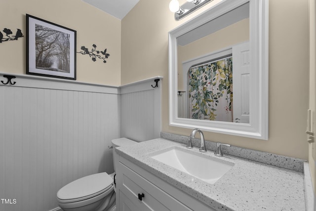 2127 Somers Ave, Burlington, NC 27215 - bathroom featuring toilet, vanity, and a wainscoted wall
