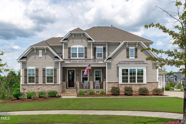 200 Baskerville Ct, Holly Springs, NC 27540 - craftsman-style home with a standing seam roof, stone siding, a porch, a shingled roof, and a front yard