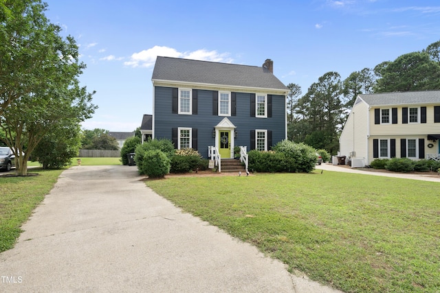 6 W Canterbury Ct, Wendell, NC 27591 - colonial-style house featuring a chimney, driveway, a front yard, and central AC