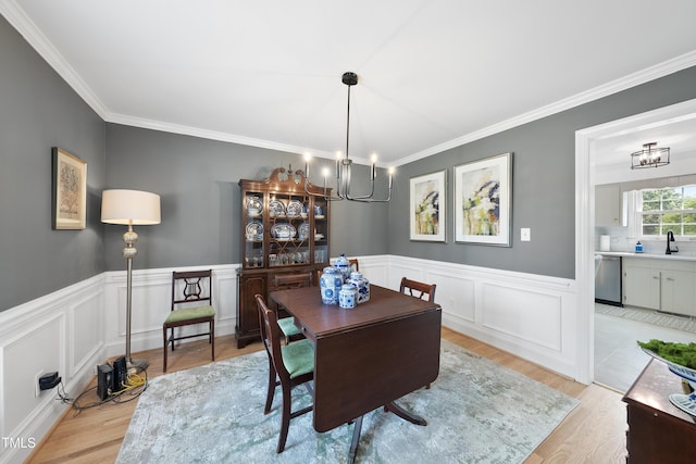 6 W Canterbury Ct, Wendell, NC 27591 - dining area with a chandelier, light wood finished floors, crown molding, wainscoting, and a decorative wall