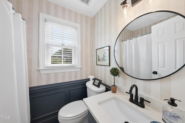 6 W Canterbury Ct, Wendell, NC 27591 - bathroom featuring wallpapered walls, wainscoting, vanity, and toilet