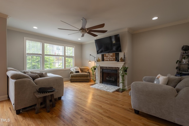 441 Heritage Village Ln, Apex, NC 27502 - living room featuring ceiling fan, light wood-style floors, a tiled fireplace, ornamental molding, and baseboards