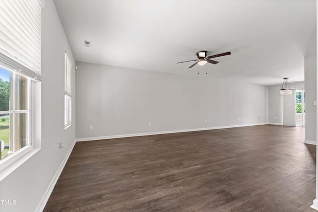218 Mason Rd, Durham, NC 27712 - unfurnished room featuring ceiling fan, baseboards, dark wood-style floors, and a chandelier