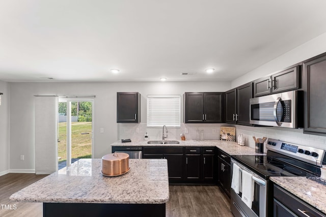 218 Mason Rd, Durham, NC 27712 - kitchen with stainless steel appliances, a sink, decorative backsplash, dark wood finished floors, and a center island
