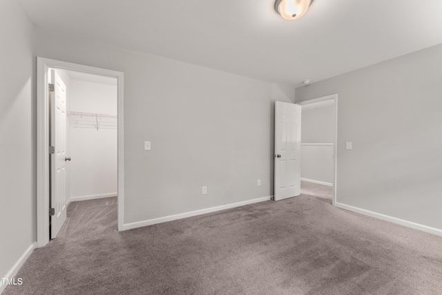 218 Mason Rd, Durham, NC 27712 - unfurnished bedroom with carpet floors, a spacious closet, a closet, and baseboards