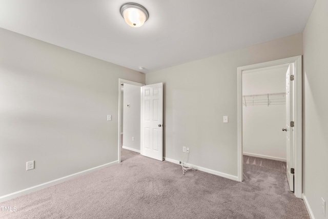 218 Mason Rd, Durham, NC 27712 - unfurnished bedroom with carpet floors, a spacious closet, baseboards, and a closet