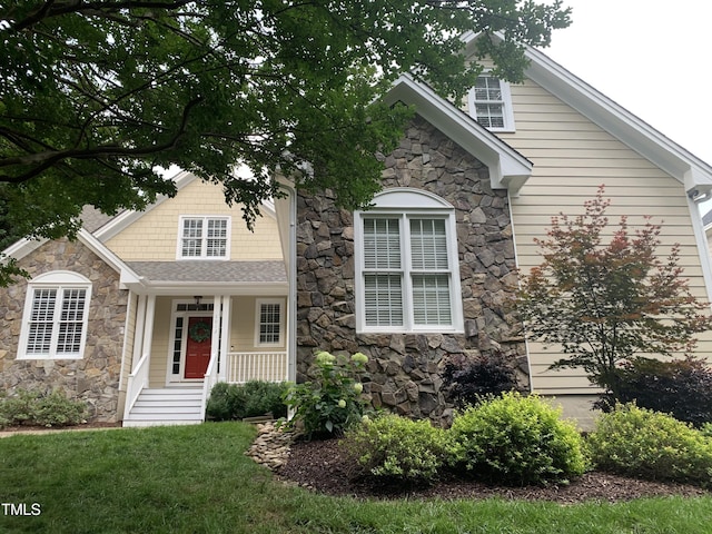 1012 Coram Fields Rd, Wake Forest, NC 27587 - view of front of property with stone siding, a front lawn, and a porch