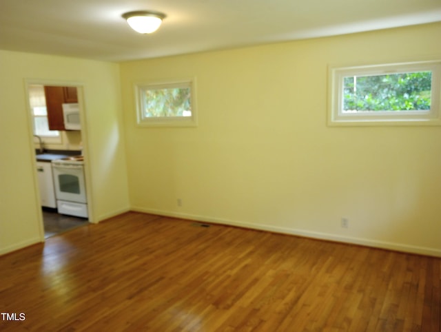 912 Dixie Trl, Raleigh, NC 27607 - spare room featuring plenty of natural light, wood finished floors, and baseboards