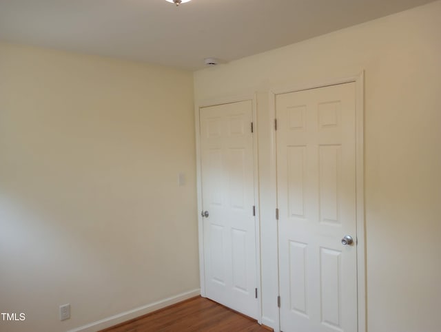 912 Dixie Trl, Raleigh, NC 27607 - unfurnished bedroom featuring wood finished floors and baseboards