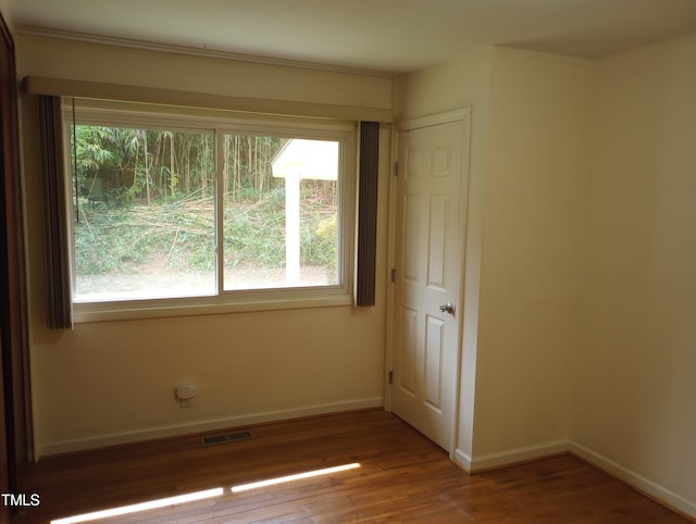 912 Dixie Trl, Raleigh, NC 27607 - empty room with wood finished floors, plenty of natural light, and baseboards